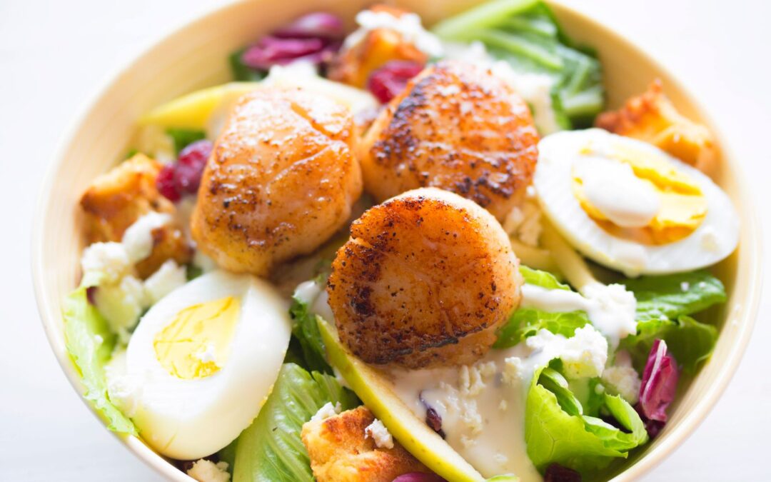 Witte kom met groene salade, gekookte eieren en verse groenten als vullende, caloriearme maaltijd
